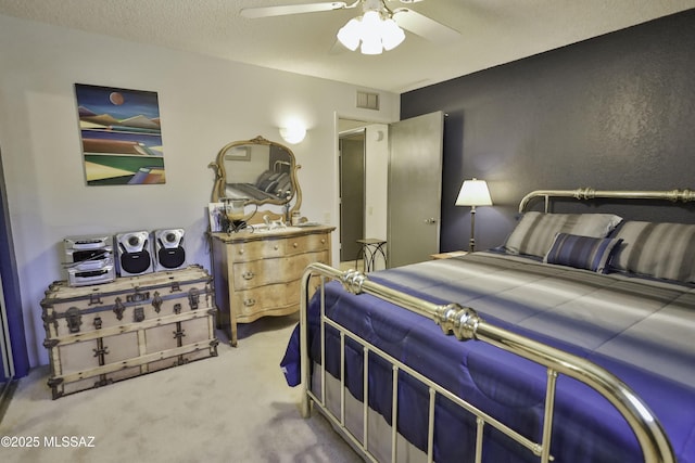 carpeted bedroom with a textured ceiling and ceiling fan