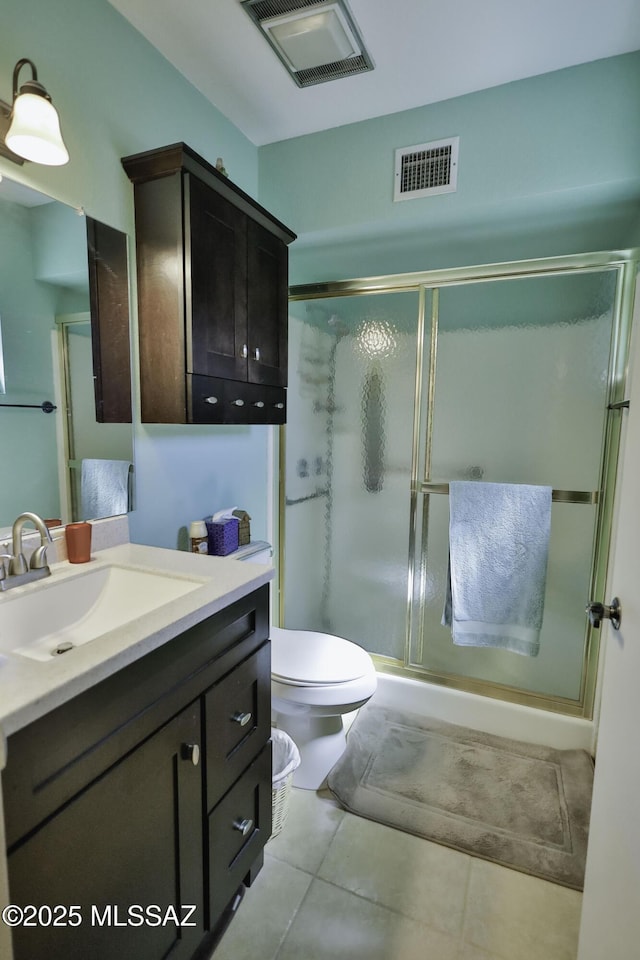 bathroom with vanity, toilet, and a shower with door