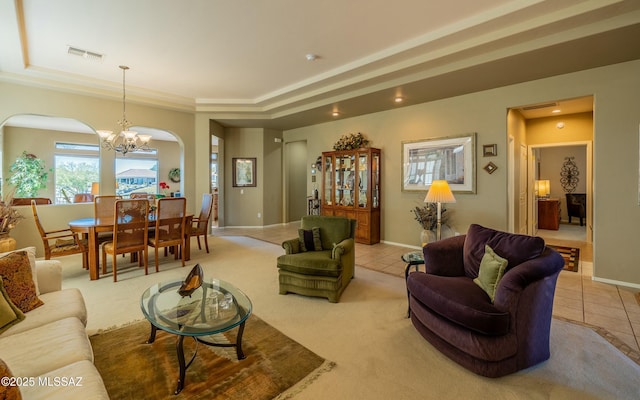 living area with a tray ceiling, an inviting chandelier, and light tile patterned floors