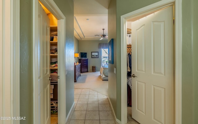 hall featuring light tile patterned flooring and baseboards