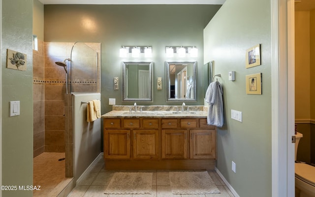 bathroom with double vanity, a walk in shower, a sink, and tile patterned floors