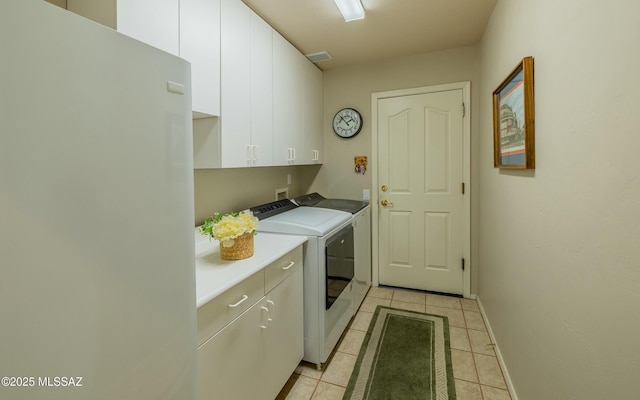 laundry area with cabinet space, visible vents, baseboards, washer and clothes dryer, and light tile patterned flooring