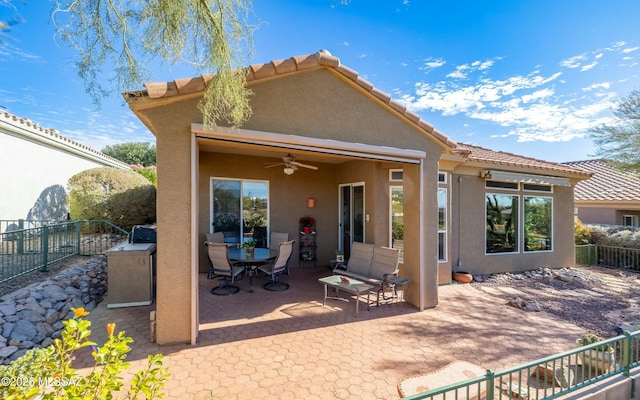 back of house featuring fence, a ceiling fan, stucco siding, outdoor dining space, and a patio area