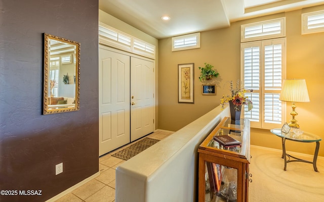 hall with light tile patterned floors, baseboards, and recessed lighting