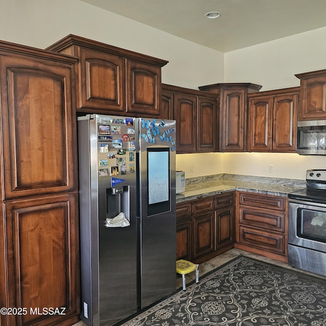 kitchen featuring dark tile patterned flooring, light stone countertops, and stainless steel appliances