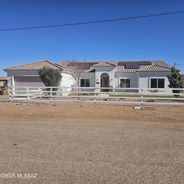 view of front of house featuring solar panels and a garage