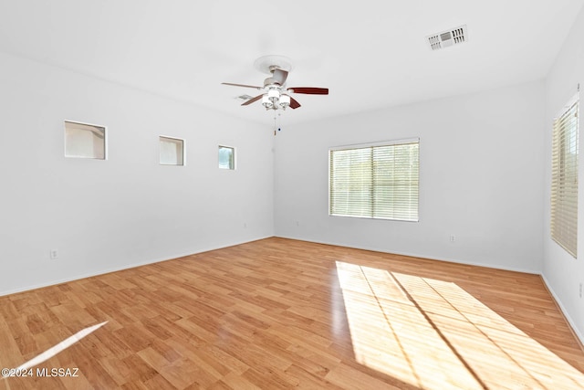 empty room with ceiling fan and light hardwood / wood-style floors