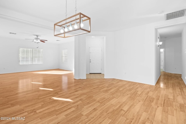 unfurnished living room with basketball hoop, light hardwood / wood-style flooring, and ceiling fan