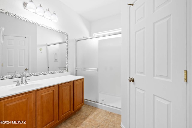 bathroom with tile patterned flooring, vanity, and walk in shower