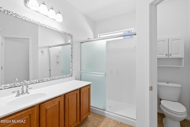 bathroom featuring vanity, an enclosed shower, and toilet