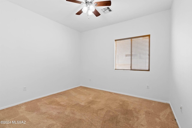 spare room featuring light carpet and ceiling fan