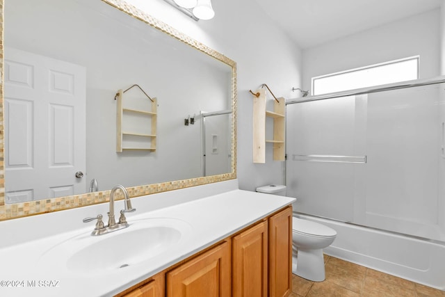 full bathroom with tile patterned flooring, vanity, toilet, and bath / shower combo with glass door