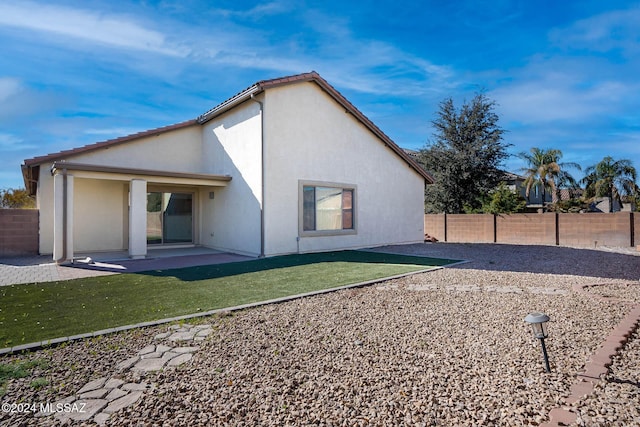 rear view of property featuring a patio area and a yard