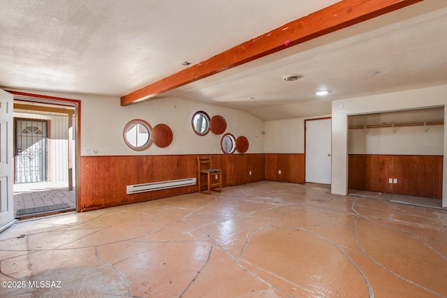 interior space with wooden walls, beam ceiling, a textured ceiling, and a baseboard heating unit