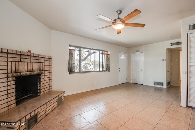 unfurnished living room featuring ceiling fan, a fireplace, and light tile patterned floors