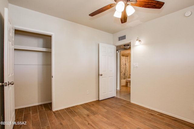 unfurnished bedroom featuring hardwood / wood-style floors, ceiling fan, and a closet