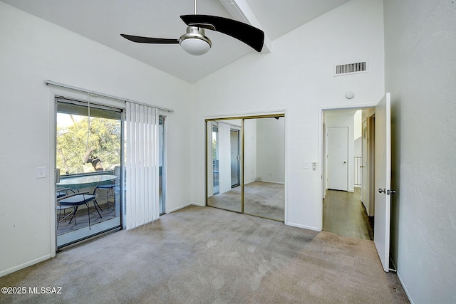 unfurnished bedroom featuring high vaulted ceiling, access to outside, light colored carpet, ceiling fan, and a closet