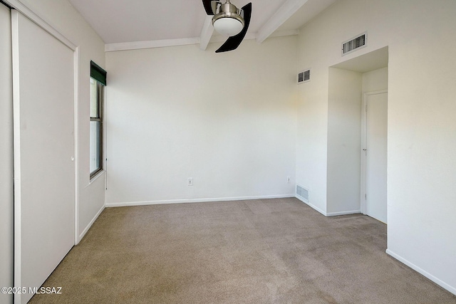 unfurnished room featuring beamed ceiling, light colored carpet, and ceiling fan