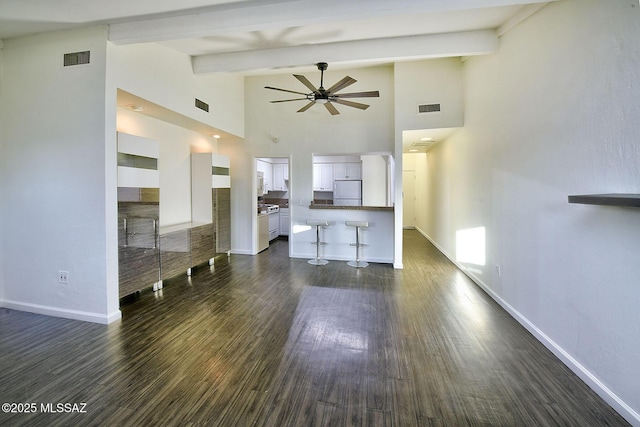 unfurnished living room with dark hardwood / wood-style floors, ceiling fan, beam ceiling, and high vaulted ceiling