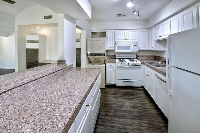 kitchen with sink, white appliances, dark wood-type flooring, white cabinetry, and stacked washer and clothes dryer