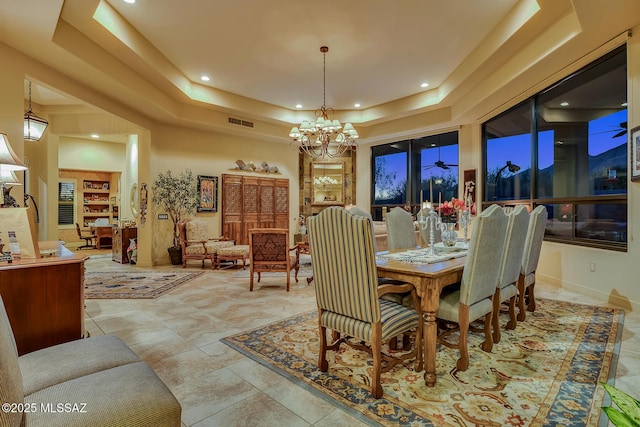 dining room featuring a tray ceiling, a towering ceiling, and an inviting chandelier