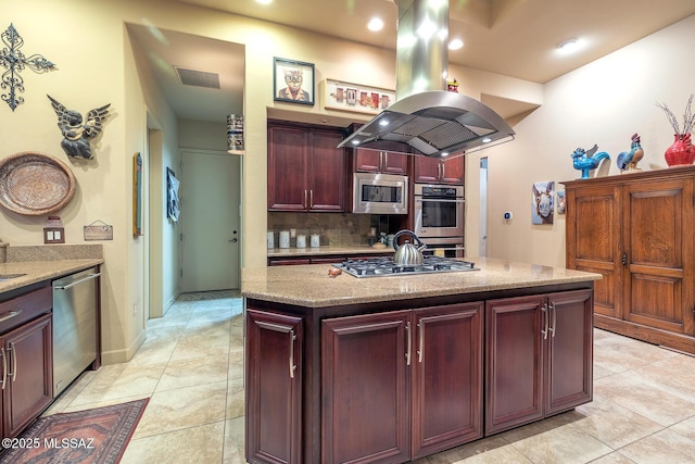 kitchen featuring island exhaust hood, stainless steel appliances, light stone counters, and a center island