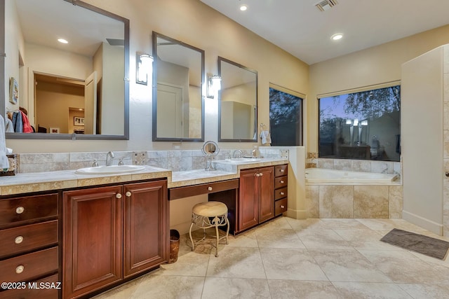 bathroom featuring tiled bath, tile patterned floors, and vanity