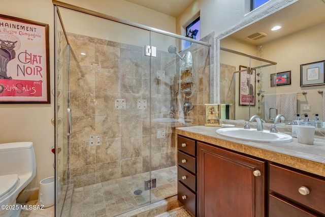 bathroom with toilet, vanity, and an enclosed shower