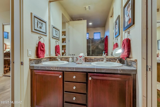 bathroom featuring decorative backsplash, hardwood / wood-style flooring, and vanity