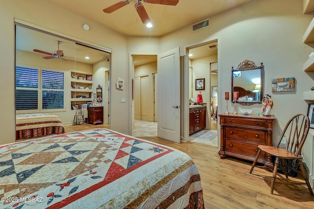 bedroom with ceiling fan, ensuite bath, and light wood-type flooring