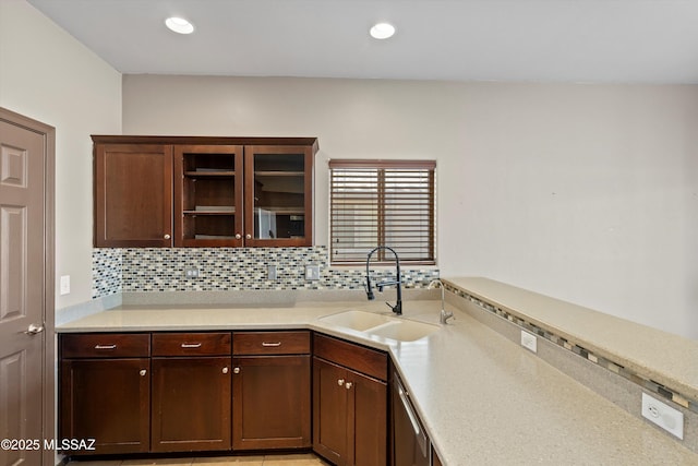 7585 E Majestic Palm Ln, Tucson, AZ 85756 - kitchen featuring a sink, light countertops, dishwasher, backsplash, and glass insert cabinets