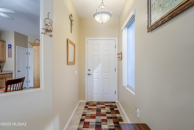 entryway featuring tile patterned floors and ceiling fan