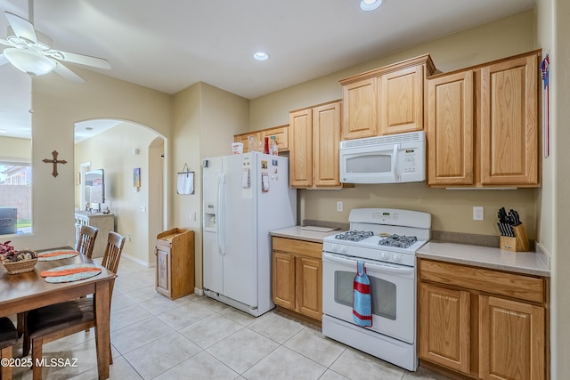 kitchen featuring ceiling fan, light brown cabinetry, light tile patterned flooring, and white appliances