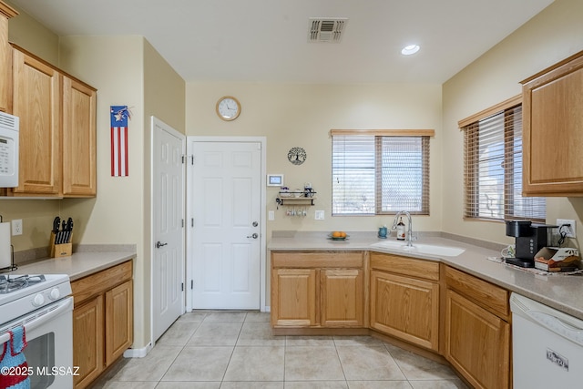 kitchen featuring white appliances, sink, and light tile patterned floors