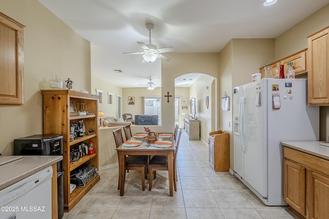 kitchen with light tile patterned floors, white appliances, ceiling fan, and light brown cabinetry