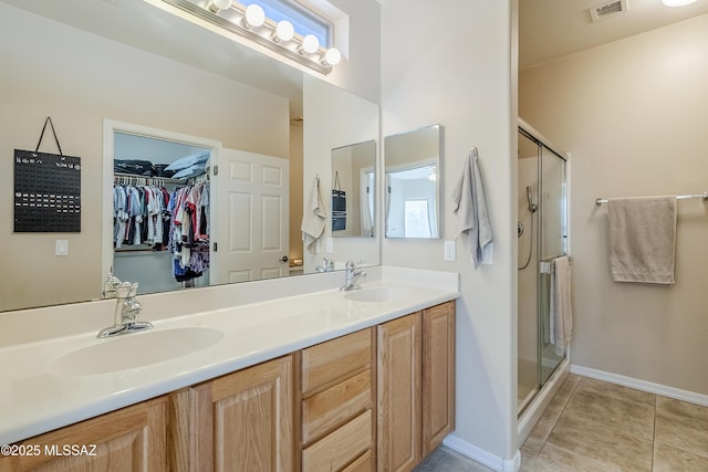 bathroom with tile patterned floors, a shower with door, and vanity