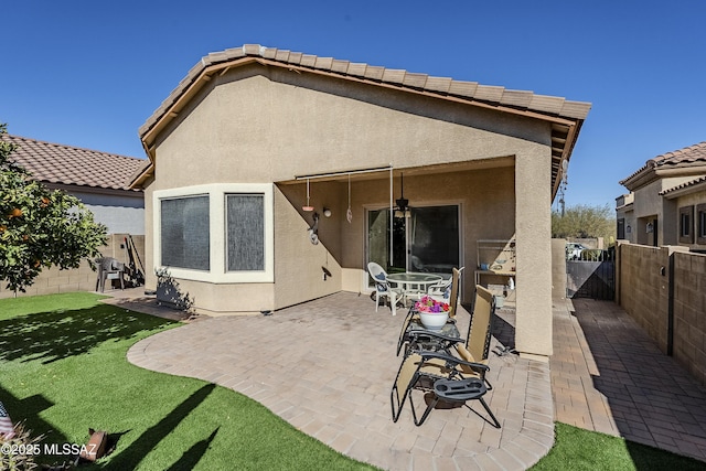 rear view of property with a yard and a patio