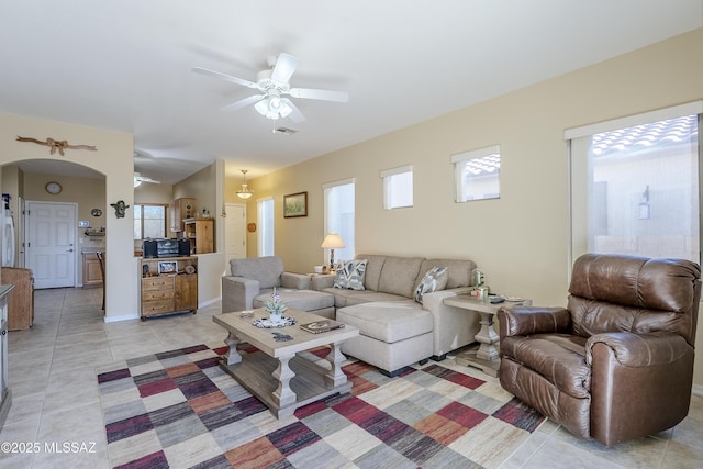 living room featuring ceiling fan, lofted ceiling, and light tile patterned flooring