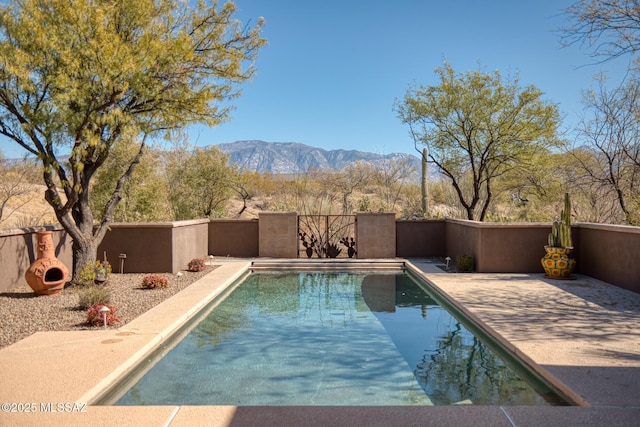 view of swimming pool with a fenced in pool, a mountain view, and fence