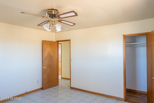 unfurnished bedroom with ceiling fan and a closet