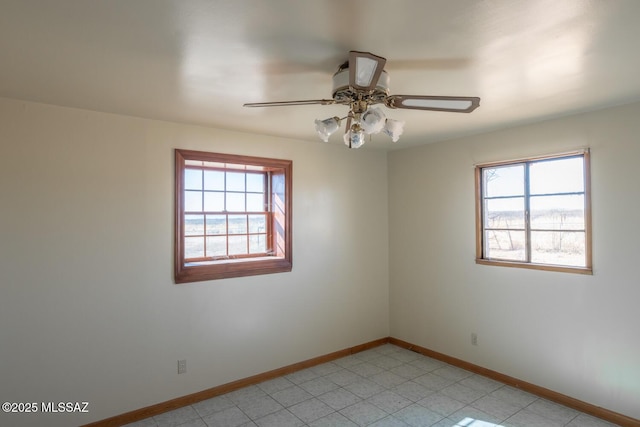 spare room featuring ceiling fan and a healthy amount of sunlight