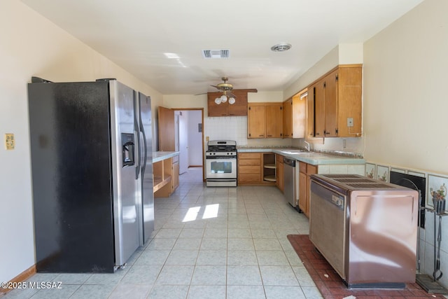 kitchen with ceiling fan, appliances with stainless steel finishes, decorative backsplash, and sink