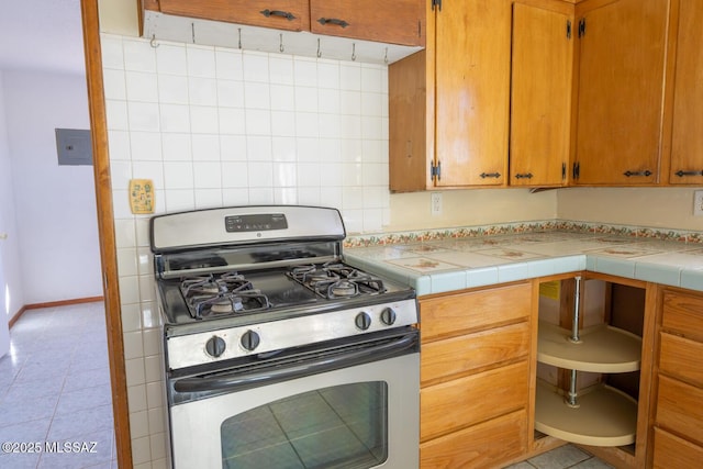 kitchen with tile counters and stainless steel range with gas stovetop