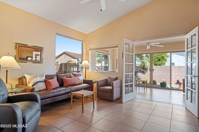 living room featuring vaulted ceiling, light tile patterned floors, ceiling fan, and french doors