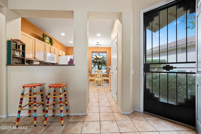 kitchen featuring an inviting chandelier, hanging light fixtures, white appliances, and light tile patterned floors