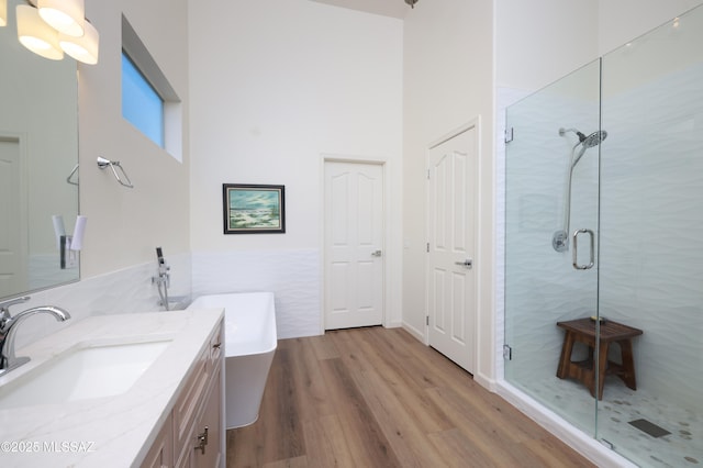 bathroom featuring wood-type flooring, vanity, and separate shower and tub