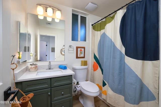 bathroom with curtained shower, toilet, and vanity