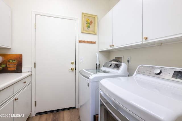 clothes washing area with dark wood-type flooring, cabinets, and washing machine and dryer