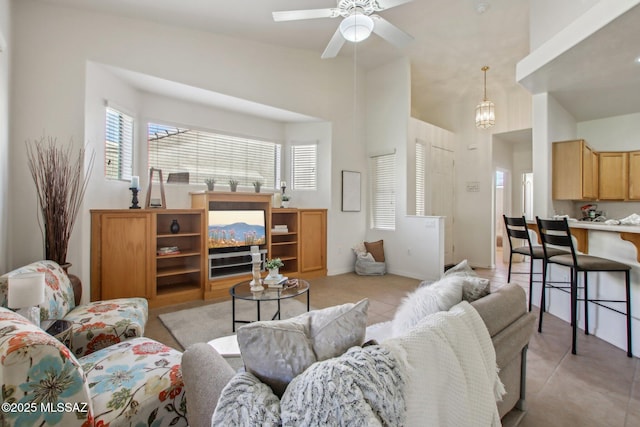 tiled living room with a high ceiling and ceiling fan