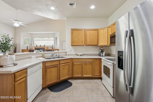 kitchen featuring light tile patterned flooring, sink, appliances with stainless steel finishes, kitchen peninsula, and ceiling fan